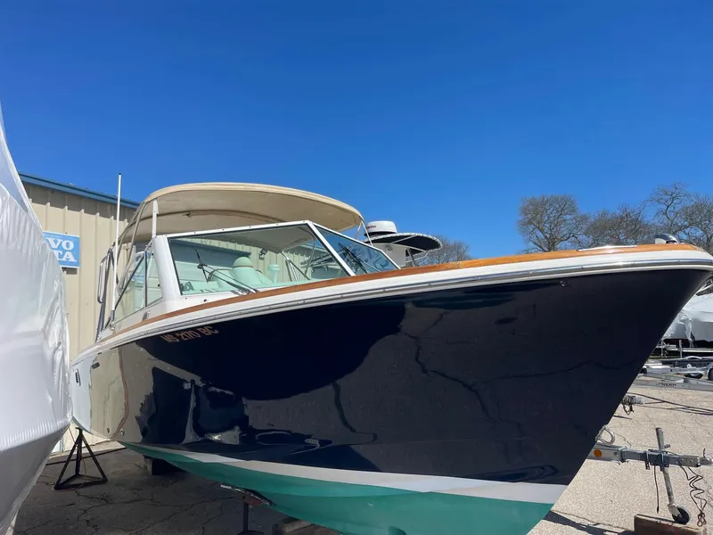 Slide: The Image of 2010 Hunt Yachts Harrier 25 boat with sleek design, docked under clear blue sky. - 2