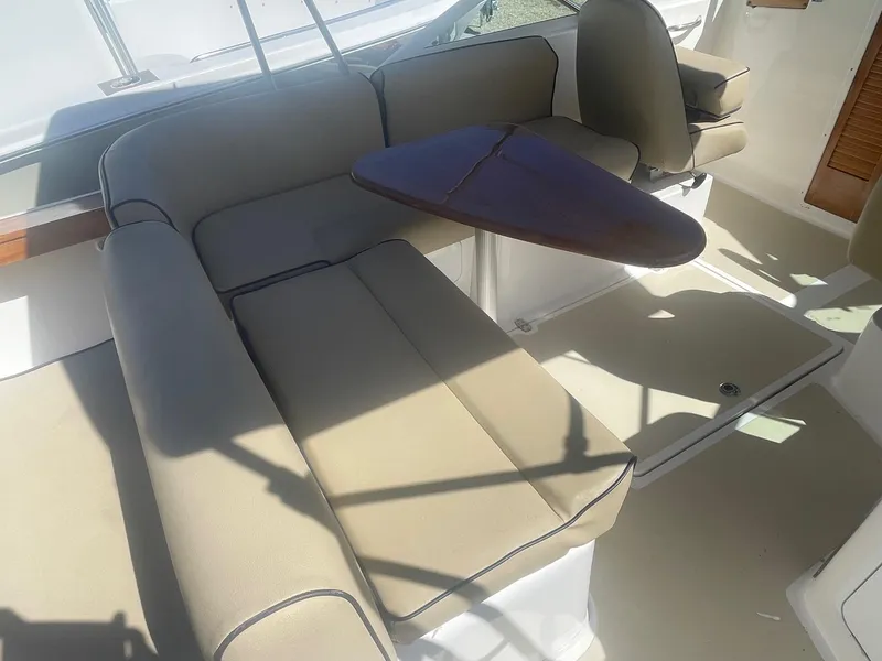 Slide: The Image of Interior seating area of 2010 Hunt Yachts Harrier 25 with beige cushions and a small table. - 20