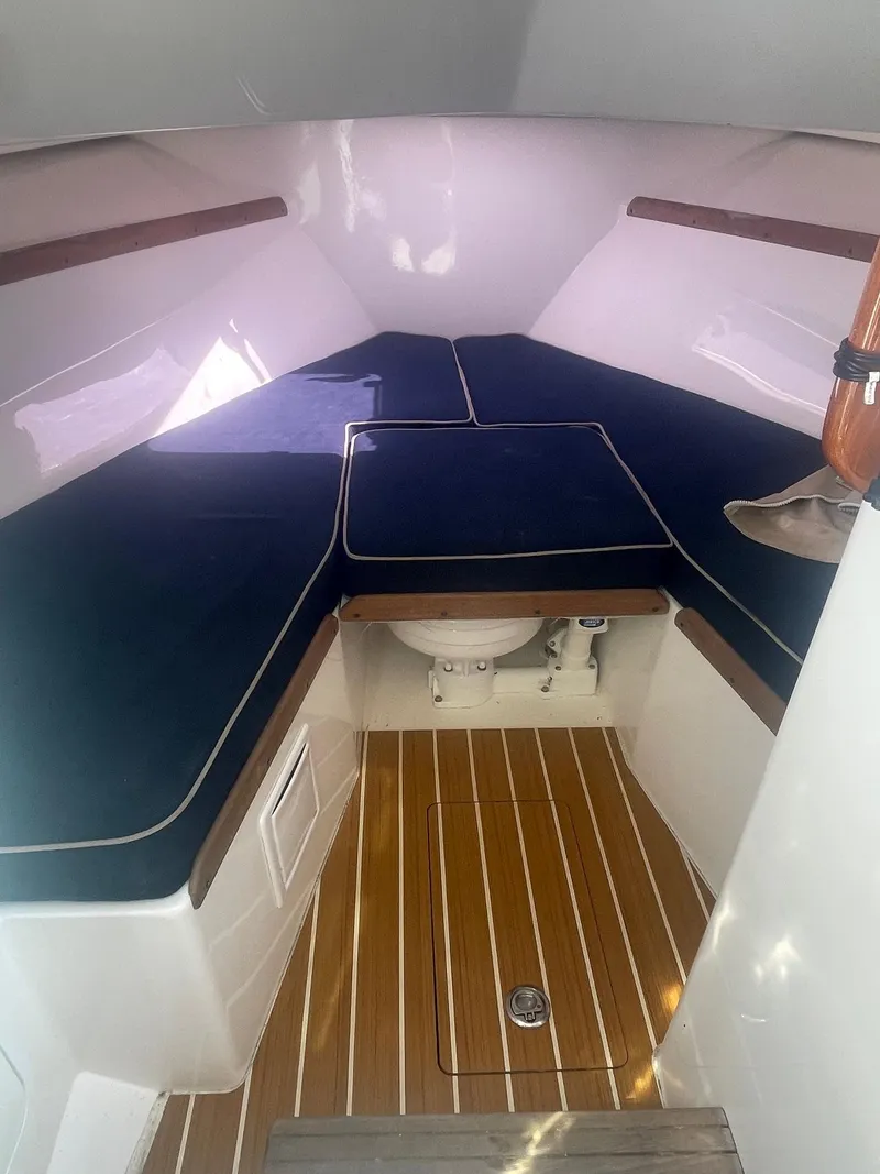 Slide: The Image of 2010 Hunt Yachts Harrier 25 cabin interior with wooden flooring and blue cushions. - 26