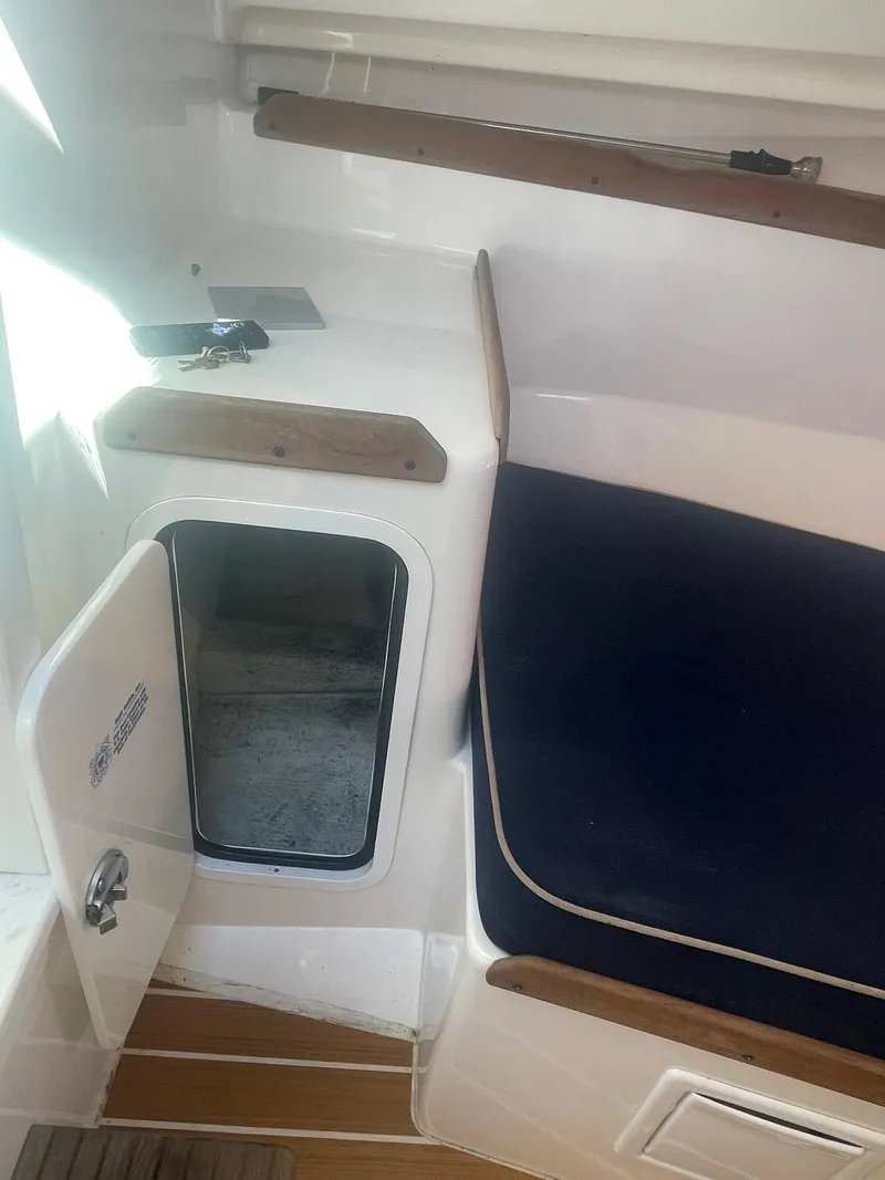 Slide: The Image of 2010 Hunt Yachts Harrier 25 interior with open storage compartment and cushioned seating. - 27