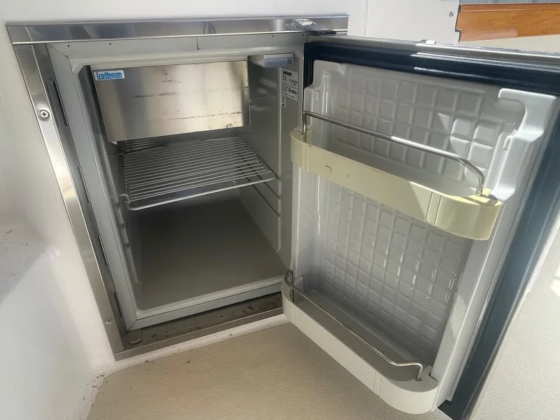 Slide: The Image of Open refrigerator on 2010 Hunt Yachts Harrier 25, showcasing interior shelving. - 29