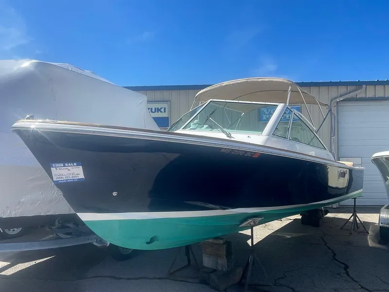 Slide: The Image of 2010 Hunt Yachts Harrier 25 boat on display, blue hull, parked outdoors. - 3