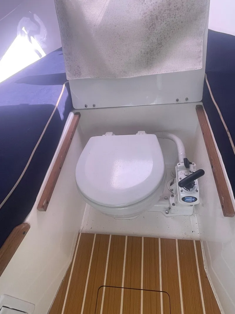 Slide: The Image of 2010 Hunt Yachts Harrier 25 boat interior with marine toilet and wooden flooring. - 32