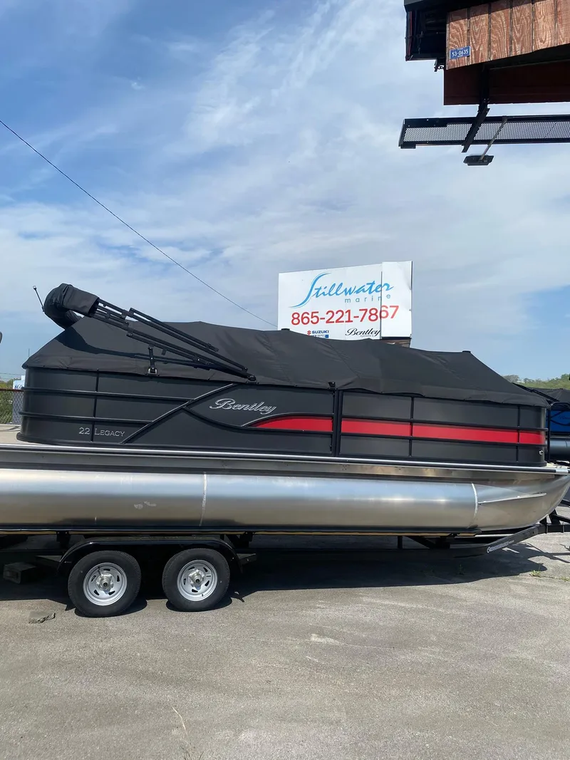 Slide: The Image of 2025 Bentley Pontoons Legacy 223 Navigator, covered, on a trailer, outdoor display. - 0