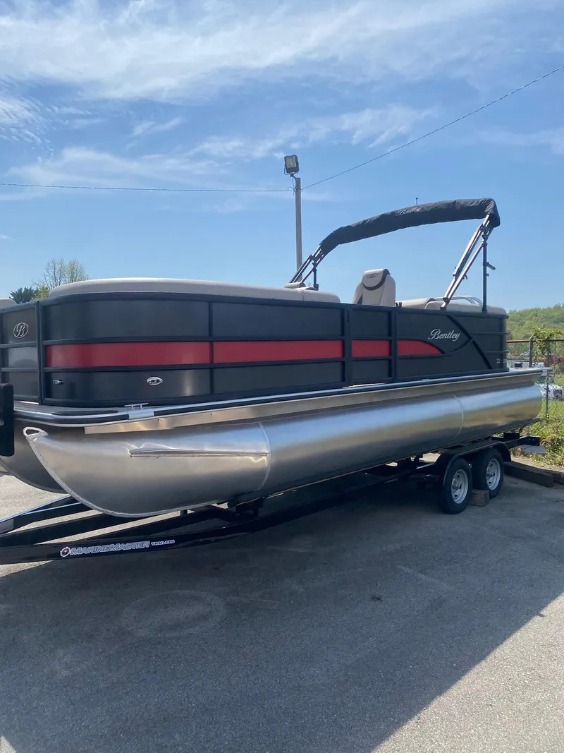 Slide: The Image of 2025 Bentley Pontoons Legacy 223 Navigator on trailer, sleek design, black and red accents. - 12