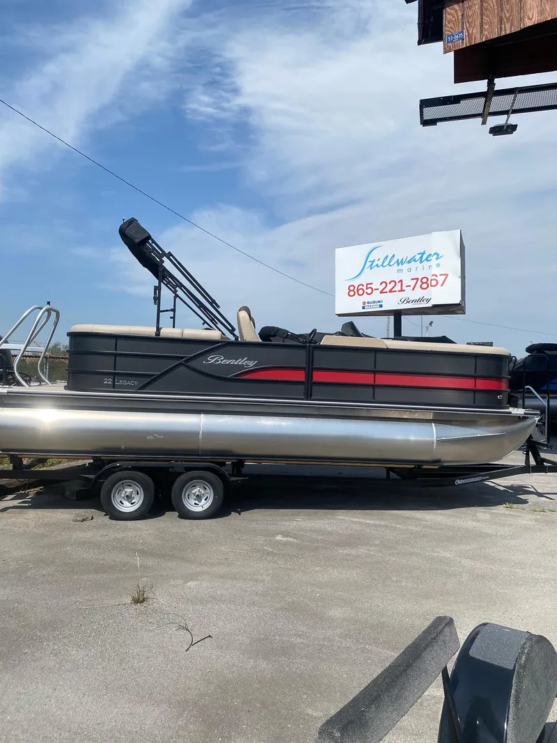 Slide: The Image of 2025 Bentley Pontoons Legacy 223 Navigator on trailer, displayed outdoors under clear sky. - 15
