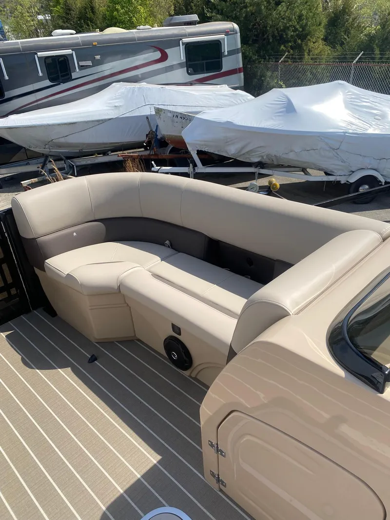 Slide: The Image of 2025 Bentley Pontoons Legacy 223 Navigator with beige seating and striped flooring. - 24