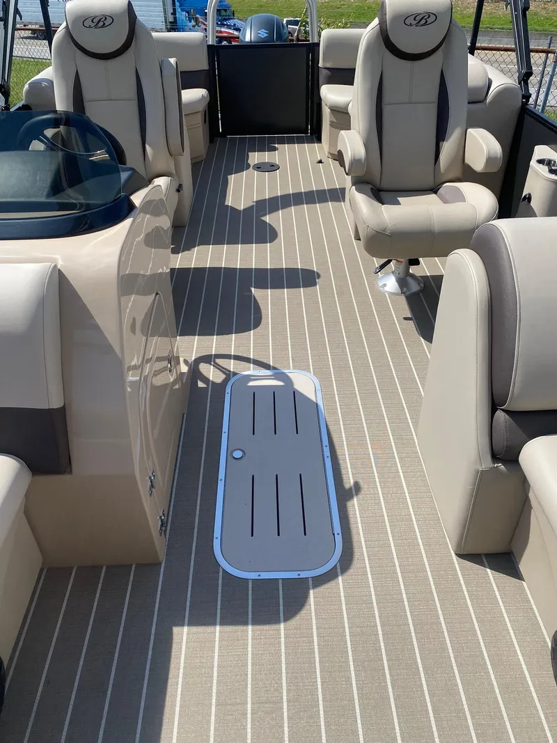 Slide: The Image of 2025 Bentley Pontoons Legacy 223 Navigator interior with beige seating and striped flooring. - 25