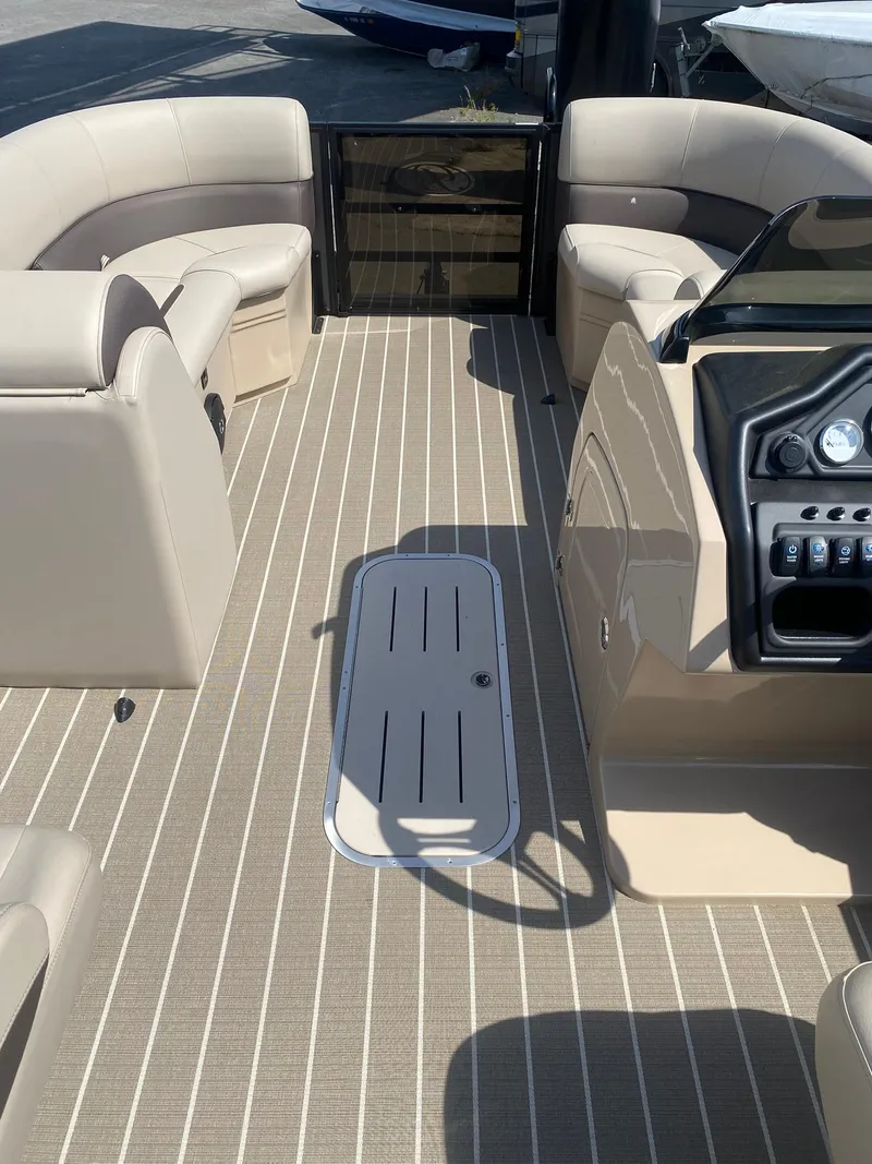 Slide: The Image of 2025 Bentley Pontoons Legacy 223 Navigator interior with beige seating and striped flooring. - 28