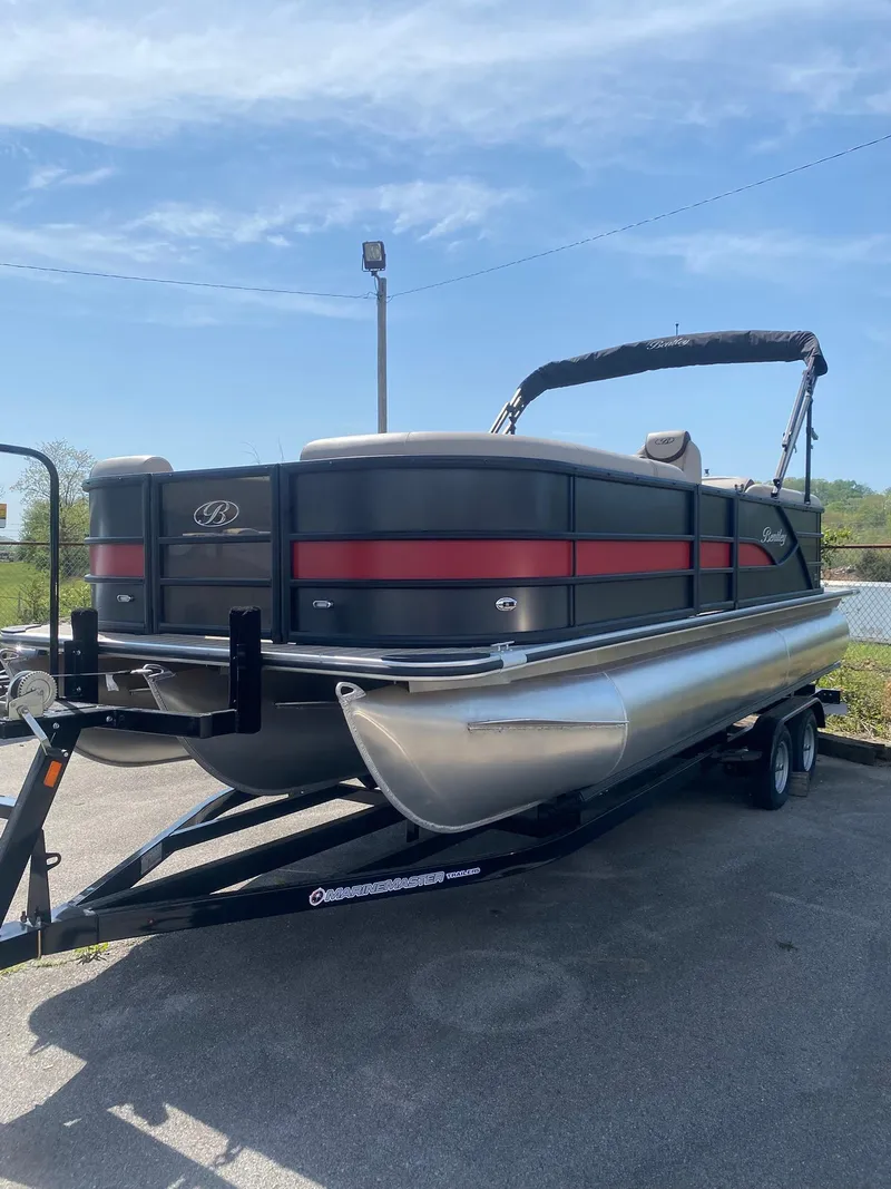 Slide: The Image of 2025 Bentley Pontoons Legacy 223 Navigator on trailer, sleek design, black and red accents. - 4