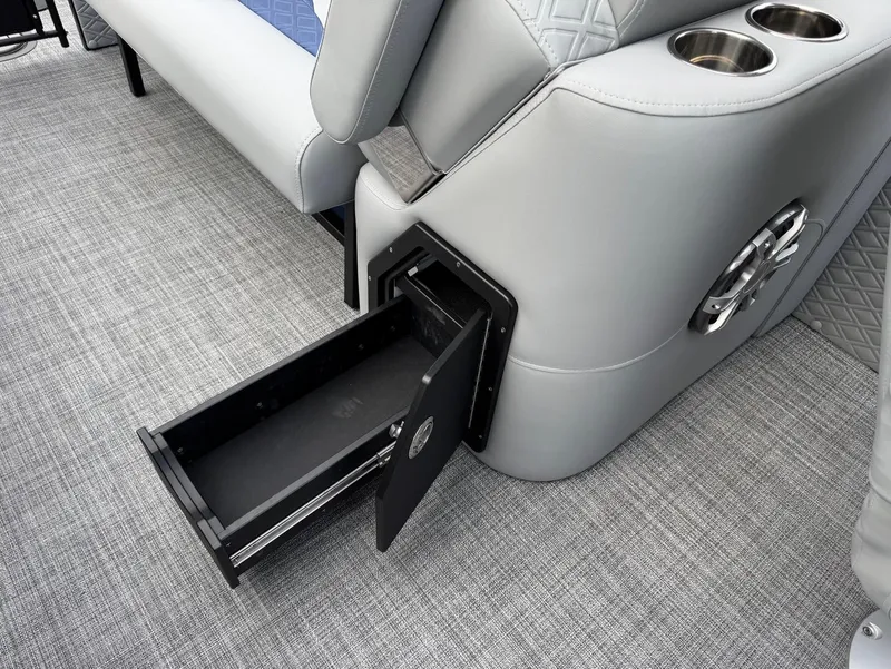 Slide: The Image of 2025 JC SportToon 24 TT DSL boat interior with storage drawer and cup holders. - 14