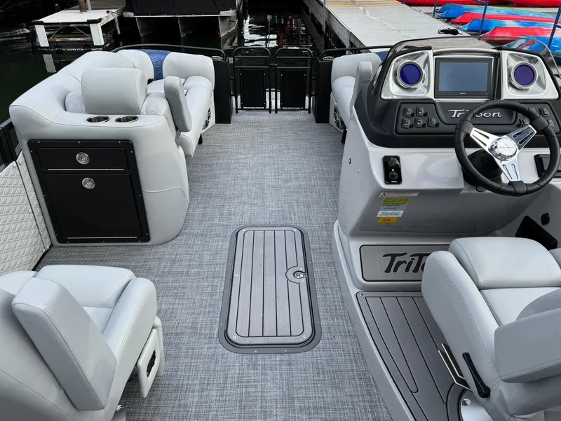 Slide: The Image of 2025 JC SportToon 24 TT DSL pontoon boat interior with modern seating and steering console. - 2