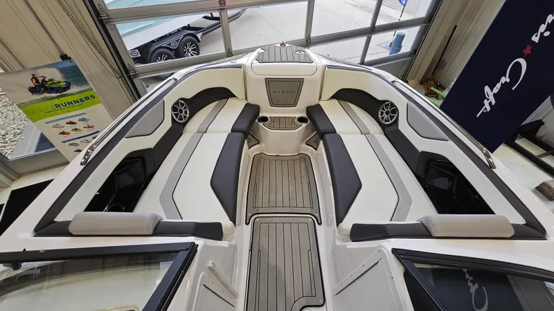 Slide: The Image of 2021 Yamaha Boats 212SD interior, featuring sleek seating and modern design in a showroom setting. - 18