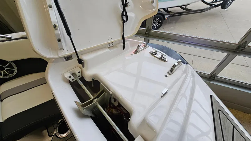 Slide: The Image of 2021 Yamaha Boats 212SD anchor storage compartment with open hatch, showcasing interior details. - 25