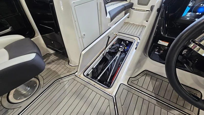 Slide: The Image of 2021 Yamaha Boats 212SD interior with open storage compartment and seating. - 27