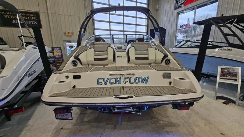 Slide: The Image of 2021 Yamaha Boats 212SD in showroom, rear view with "Even Flow" text. - 4