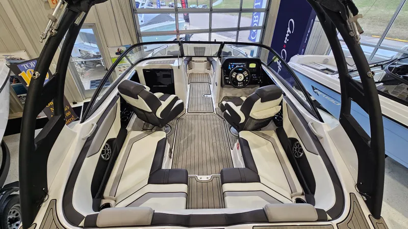 Slide: The Image of 2021 Yamaha Boats 212SD interior with sleek seating and modern dashboard in showroom. - 7