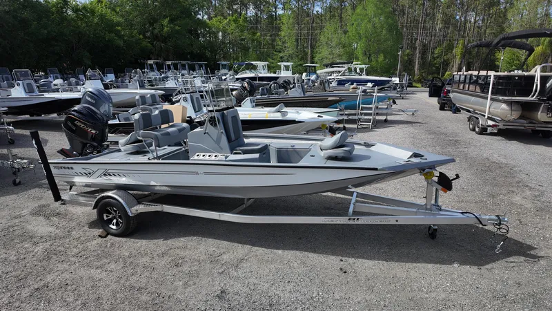 Slide: The Image of 2025 Xpress H20B boat on trailer in outdoor showroom. - 1