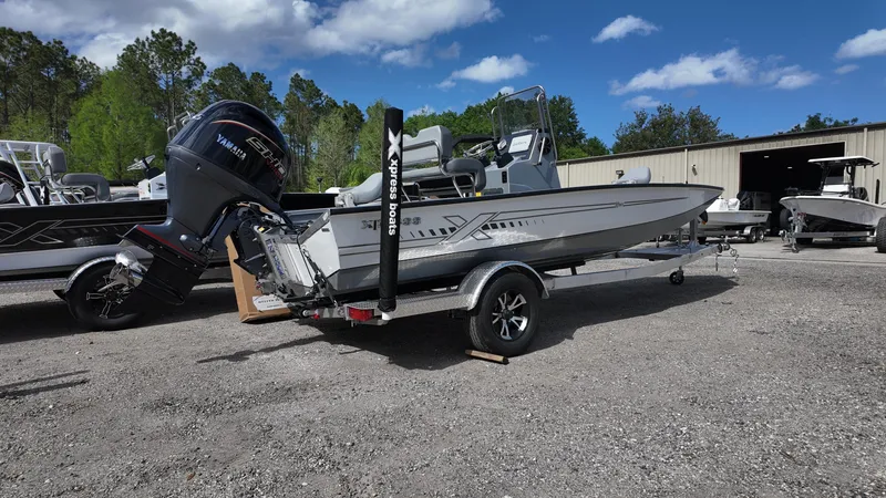 Slide: The Image of 2025 Xpress H20B boat on trailer with Yamaha outboard motor, parked outdoors. - 12