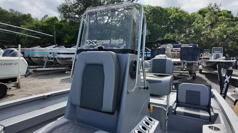 Slide: The Image of 2025 Xpress H20B boat with sleek seating and console, displayed outdoors among other boats. - 23