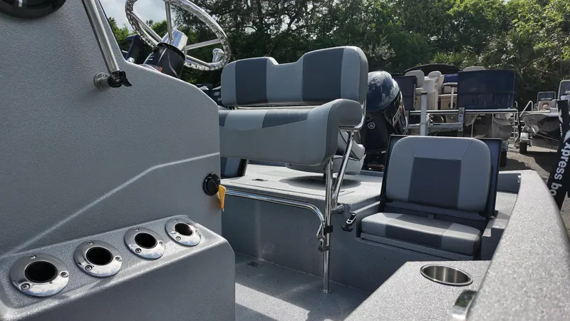 Slide: The Image of 2025 Xpress H20B boat interior with seating and steering wheel, featuring rod holders and cup holders. - 24