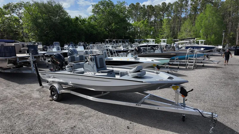 Slide: The Image of 2025 Xpress H20B boat on trailer in a dealership lot, surrounded by other boats. - 5