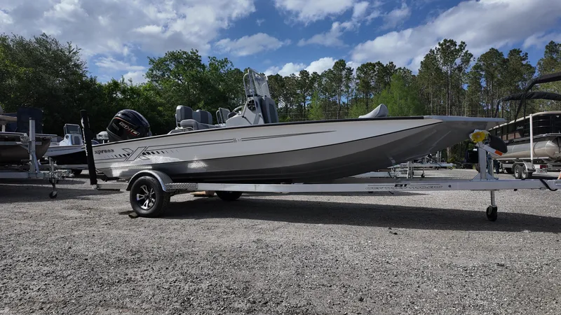 Slide: The Image of 2025 Xpress H20B boat on trailer, parked outdoors under a partly cloudy sky. - 6