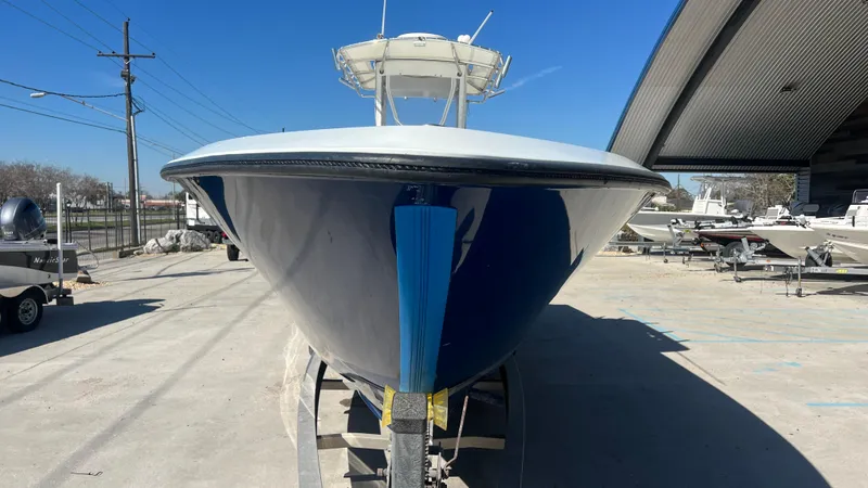 Slide: The Image of 2005 Contender 36 boat, front view, parked outdoors under clear blue sky. - 4