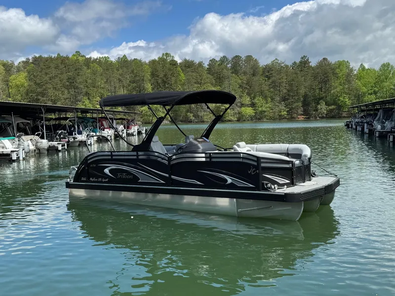 The Image of 2025 JC Neptoon Sport 23TT DSL pontoon boat on a serene lake. - 0
