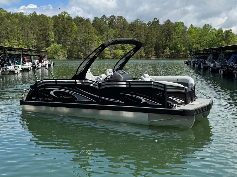 Slide: The Image of 2025 JC Neptoon Sport 23TT DSL pontoon boat on a serene lake. - 1