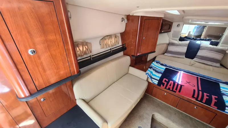 Slide: The Image of 2007 Sea Ray 290 Sundancer cabin interior with seating, bed, and wooden cabinetry. - 11