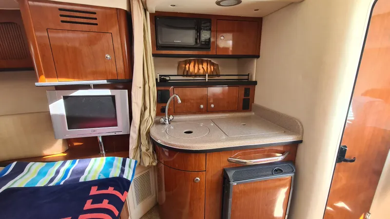 Slide: The Image of 2007 Sea Ray 290 Sundancer interior with kitchenette, TV, and microwave. - 13