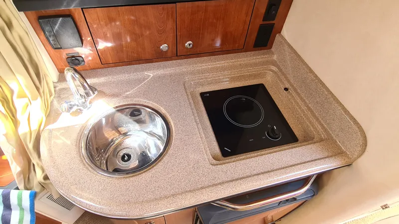 Slide: The Image of 2007 Sea Ray 290 Sundancer galley with sink and stovetop. - 14