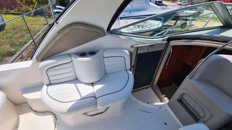 Slide: The Image of 2007 Sea Ray 290 Sundancer boat interior with white seating and open cabin door. - 28