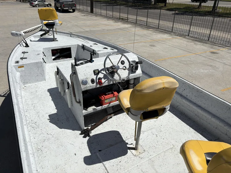 Slide: The Image of 2011 Skiff Reno 22 boat with yellow seats and steering wheel in a parking lot. - 10