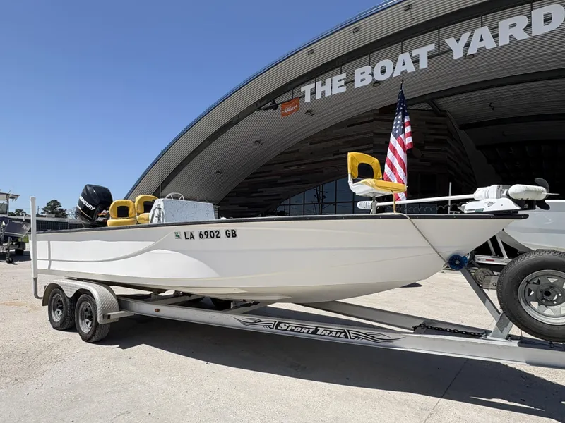 Slide: The Image of 2011 Skiff Reno 22 boat on trailer at The Boat Yard, featuring an American flag. - 3