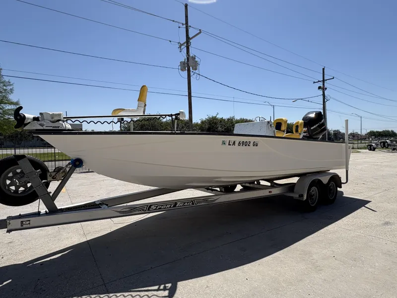 Slide: The Image of 2011 Skiff Reno 22 boat on trailer, parked outdoors under clear sky. - 8