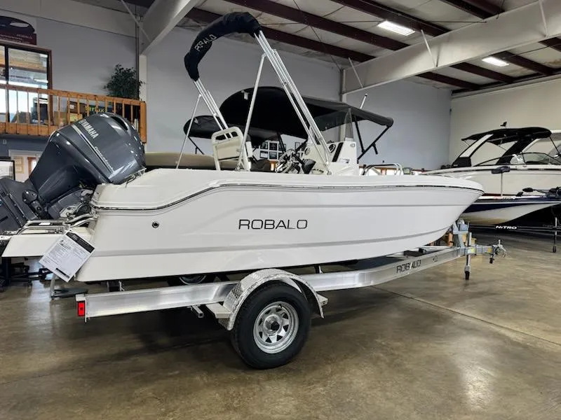Slide: The Image of 2025 Robalo R160 Center Console boat on trailer in showroom. - 1