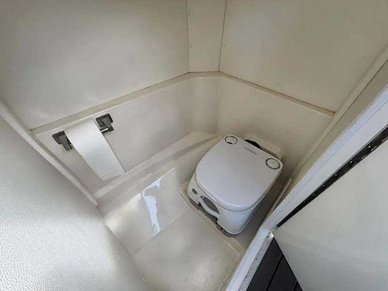 Slide: The Image of 2022 Sea Ray SPX 230 boat interior with compact marine toilet. - 13