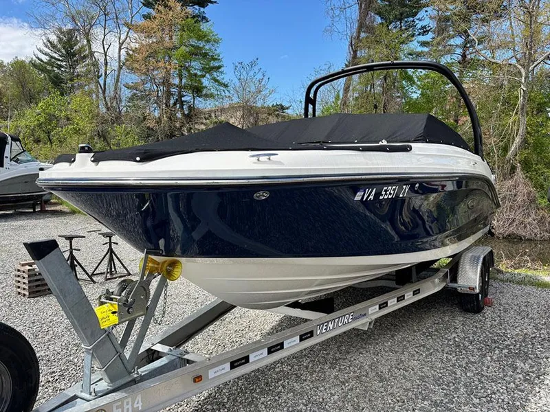 Slide: The Image of 2022 Sea Ray SPX 230 boat on trailer, covered, parked outdoors. - 2