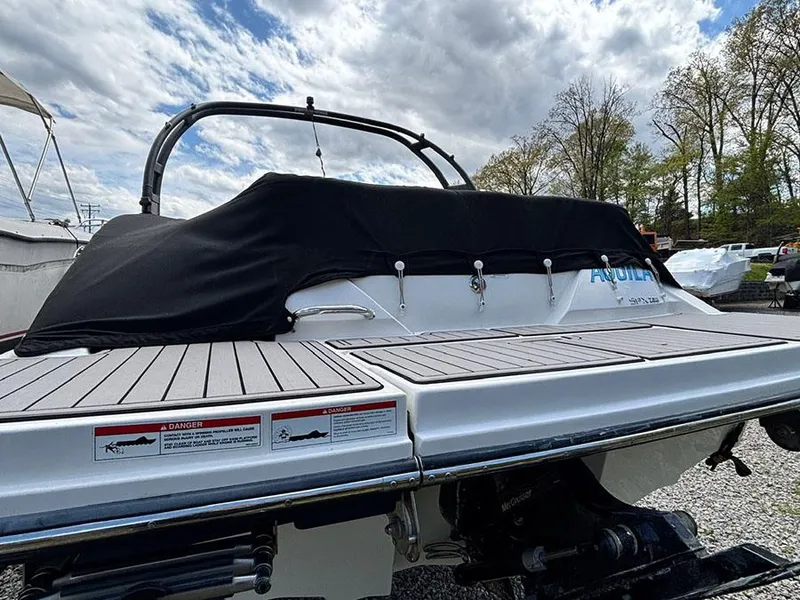 Slide: The Image of 2022 Sea Ray SPX 230 boat with covered deck, parked outdoors under cloudy sky. - 3