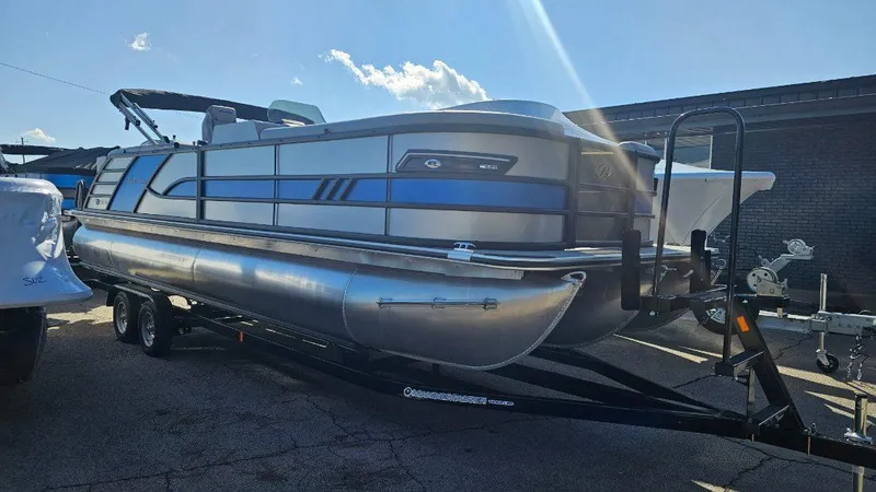Slide: The Image of 2025 Bentley Pontoons Elite 253 Admiral on trailer, sleek design under sunny sky. - 1