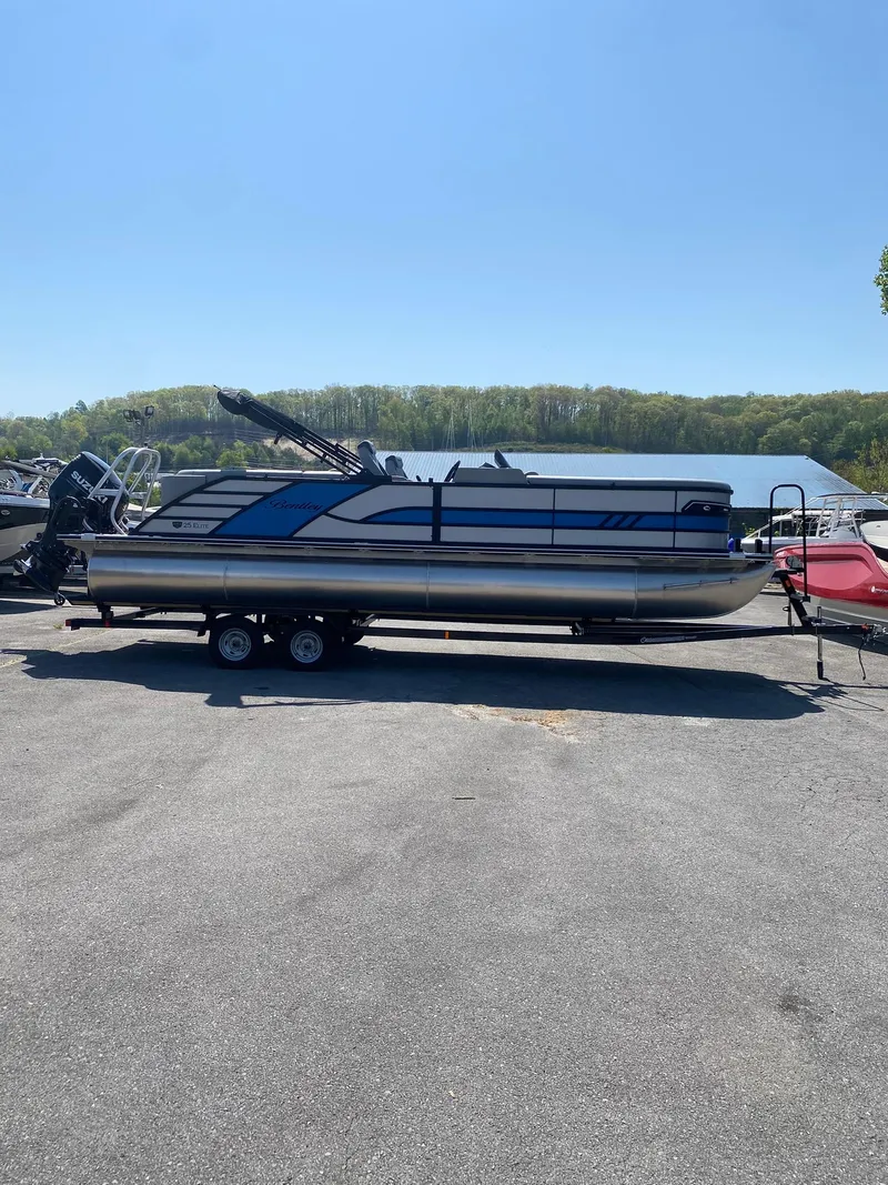 Slide: The Image of 2025 Bentley Pontoons Elite 253 Admiral on trailer by a lake. - 17
