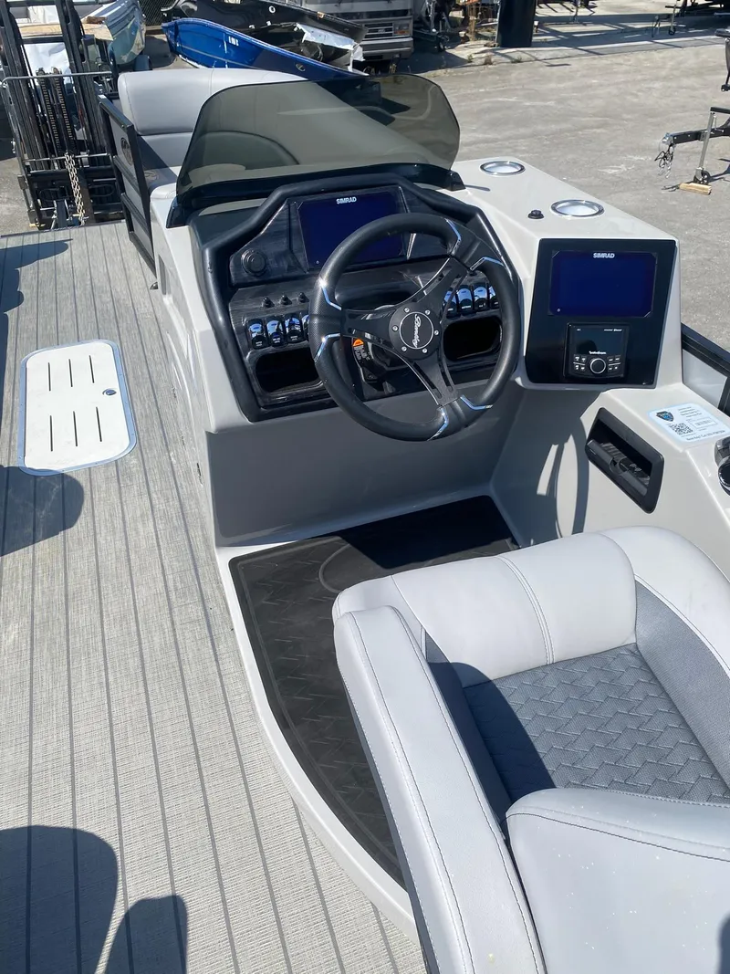 Slide: The Image of 2025 Bentley Pontoons Elite 253 Admiral dashboard with steering wheel and digital displays. - 26