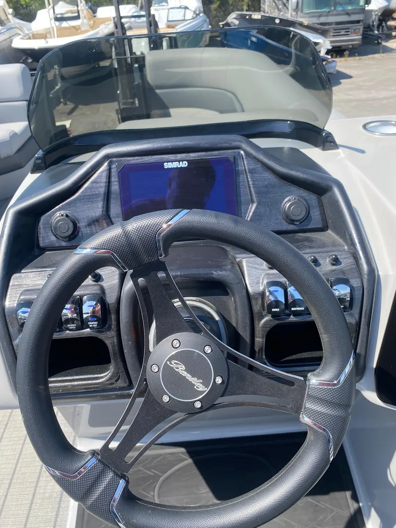 Slide: The Image of 2025 Bentley Pontoons Elite 253 Admiral dashboard with steering wheel and control panel. - 35