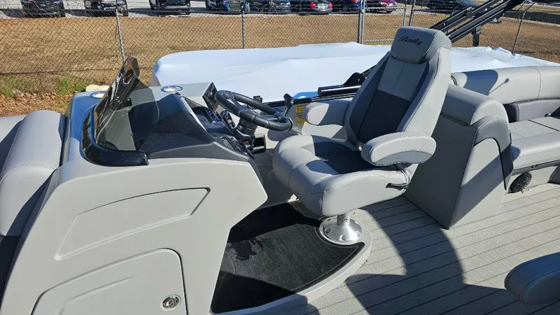 Slide: The Image of 2025 Bentley Pontoons Elite 253 Admiral interior with captain's chair and steering console. - 4