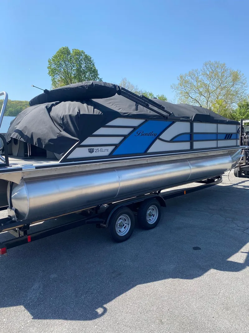Slide: The Image of 2025 Bentley Pontoons Elite 253 Admiral on trailer, covered, outdoors. - 8