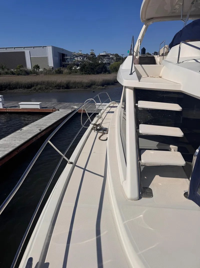 Slide: The Image of Aquila 48 yacht docked at marina, showcasing sleek design and spacious deck, 2018 model. - 13