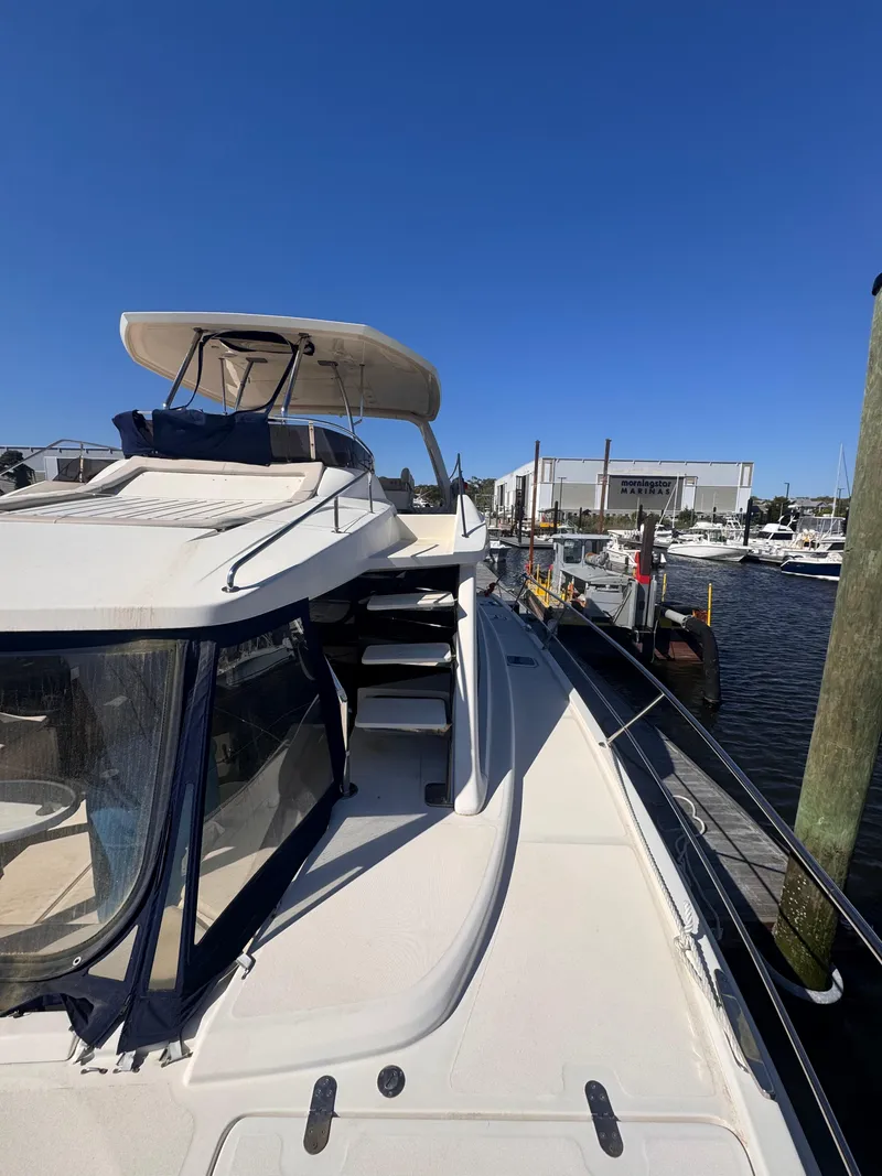 Slide: The Image of Aquila 48 yacht docked at marina, showcasing sleek design and spacious deck, 2018 model. - 14