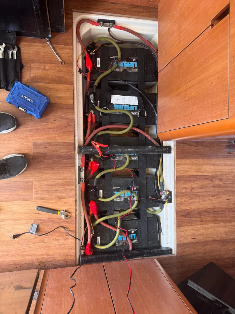 Slide: The Image of Battery compartment of a 2018 Aquila 48 yacht with wiring and tools visible. - 25